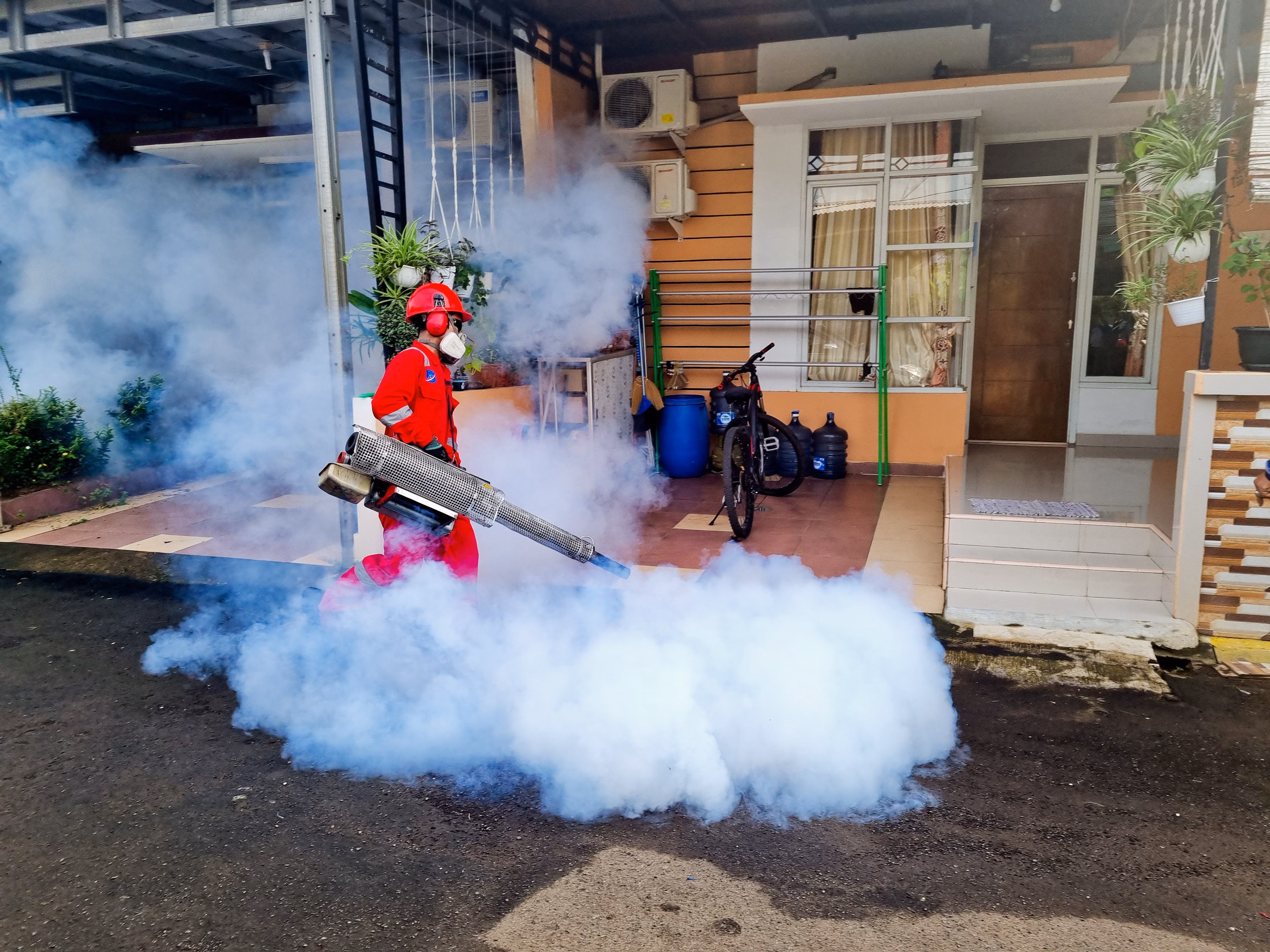 Técnico realizando un tratamiento profesional en el exterior de una vivienda